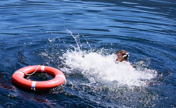 A man struggling for a life buoy in the water