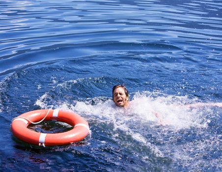 A man struggling for a life buoy in the water