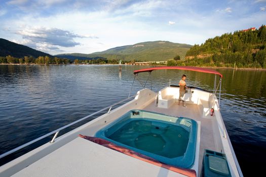 A young male at the helm of a luxury boat