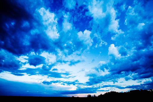 A blue evening sky with clouds on the prairie