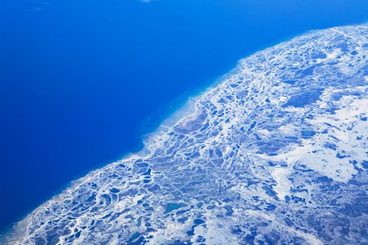 An aerial view of a melting glacier in the ocean.