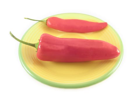 two red hot peppers on a tyellow plate