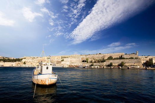 An old harbour with a fishing boat.  Valletta, Malta