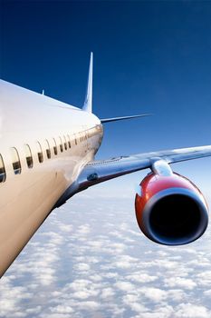 An airplane in flight over a blue sky