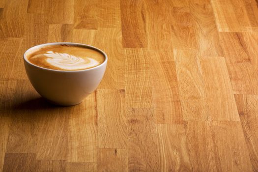 A warm specialty coffe on a wood table