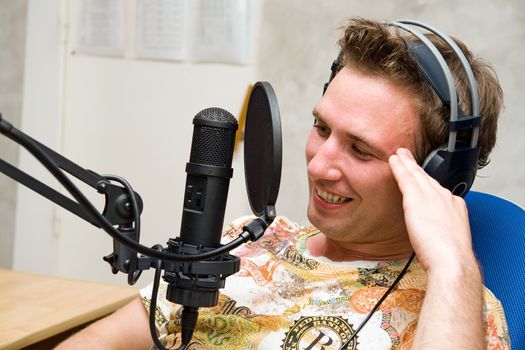 Radio DJ.  Young man with microphone and big headphone.