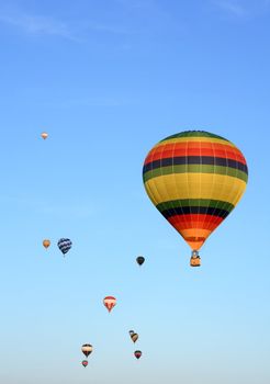 Many colorful hot air balloons in the blue sky.