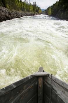 An old wooden goat going down wild rapids