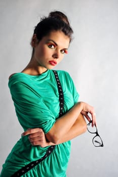 smiling girl posing in a green dress with glasses