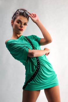 smiling girl posing in a green dress with glasses