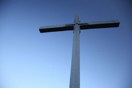 big metal cross and an evening sky with moon
