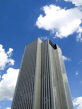 High modern skyscraper on a background of a blue sky and clouds.