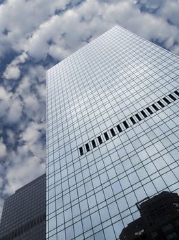 High modern skyscraper on a background of a blue sky and clouds.