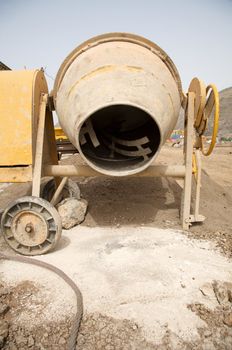 front view of a yellow working cement mixer