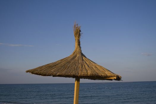 Close-up of single umbrella against blue sky and sealine