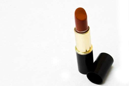 Maroon lipstick with lid off isolated against white background