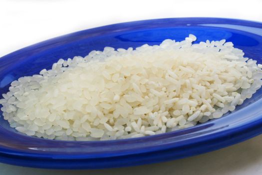 White uncooked rice on blue plate
