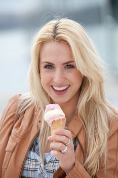 Pretty young blond girl with an icecream looking happy