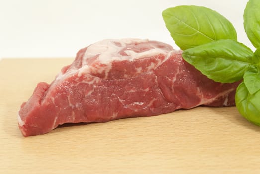 piece of beef with basil leaves