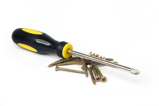 Yellow and black handled phillips screwdriver with pile of scews on white background