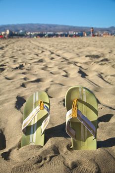 green flip-flop on the sand of a spanish beach