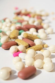Various pills against white background with shallow depth of field on midground