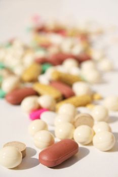 Various pills against white background with shallow depth of field on foreground