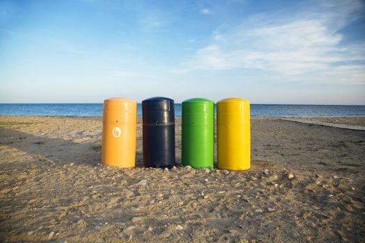 four coloured garbage barrels at the beach of mazarron murcia spain