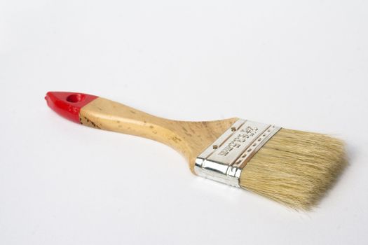 A small wooden handled paint brush isolated against a white background