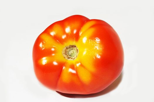 Red tomato with yellow markings on white background