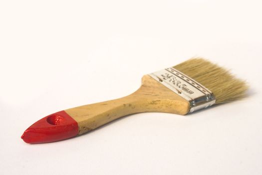 A small wooden handled paint brush isolated against a white background