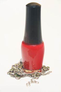 A bottle of red fingernail polish with green necklace wrapped around