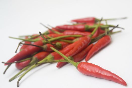 An arrangement of small red chili peppers isolated against a white background