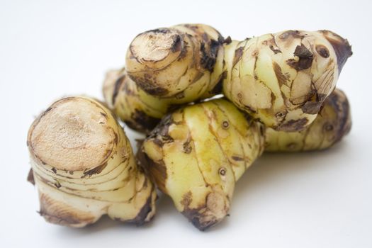 A stack of galangal root isolated against a white background