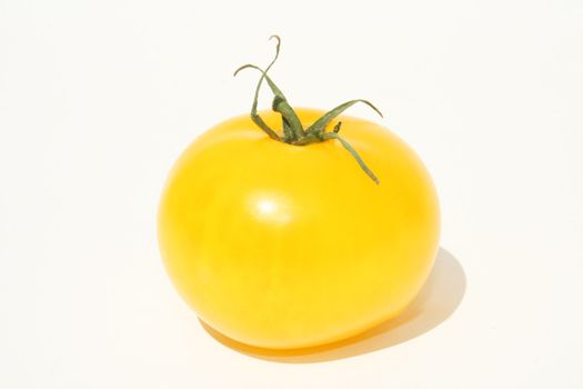 Single yellow tomato on white background