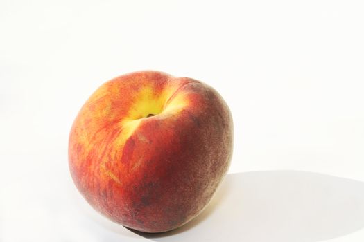Single peach against white background