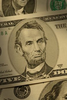 Close-up of Abraham Lincoln on the $5 bill, dramatically lit.