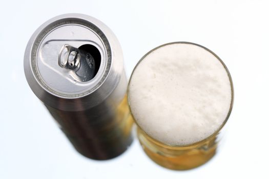 Closeup of beer glass and can on white background