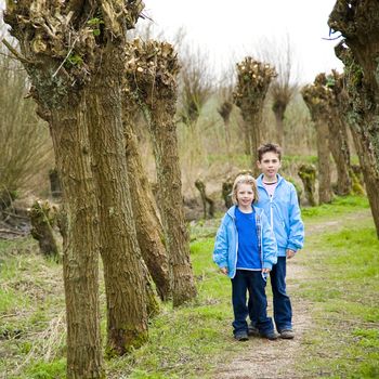 Two children standing in the woods