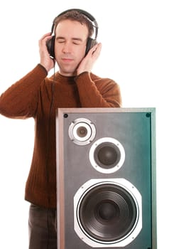 A young man is listening to music with a pair of headphones, isoated against a white background