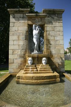 fountain with an statue and two masks