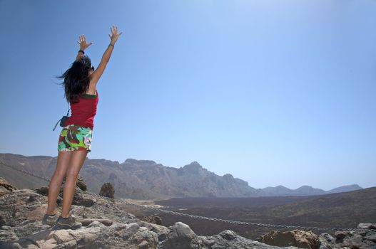 woman opening arms near the teide volcano in tenerife spain