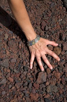 woman hand on volcanic stones