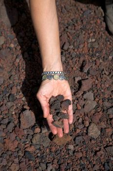 woman hand pick up volcanic stones