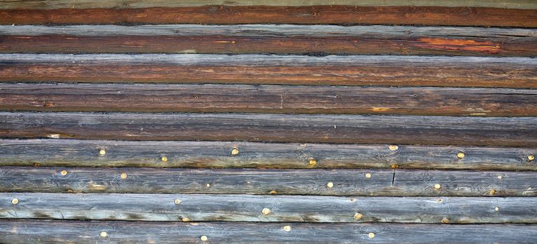 Old wooden rotten wall of a log hut