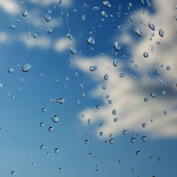 Water droplets on glass against the sky