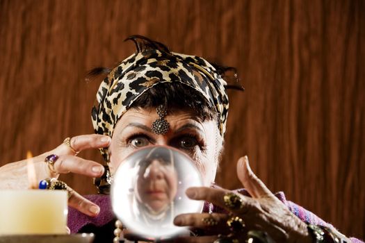 Female gypsy fortune teller looking into a crystal ball