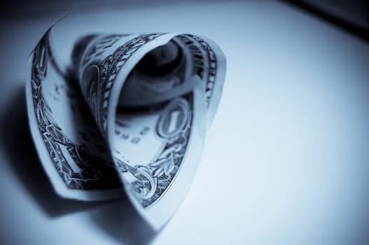 A rolled up one dollar bill isolated on a white background
