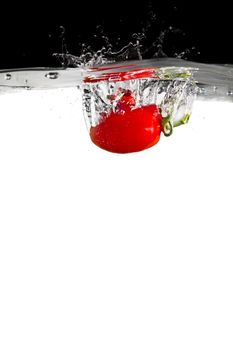 one tomato thrown in water with black and white background