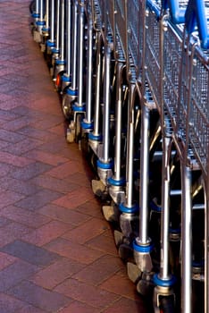 Empty shopping carts lined at the supermarket ready to be picked up